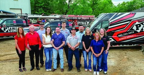The Pither Plumbing team photographed together in front of the company trucks